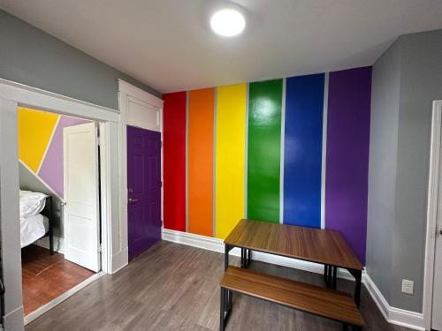 a room with a colorful wall with a wooden table at Cute Neighborhood Rainbow Apt in Saint Louis