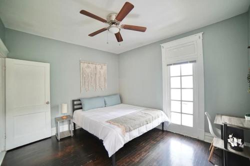 a bedroom with a bed with a ceiling fan at Cute Neighborhood Rainbow Apt in Saint Louis