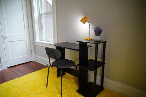a desk with a lamp and a chair in a room at Cute Neighborhood Rainbow Apt in Saint Louis