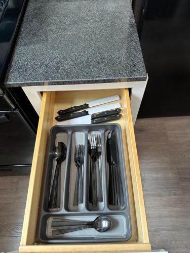 a drawer in a counter with utensils in it at Cute Neighborhood Rainbow Apt in Saint Louis