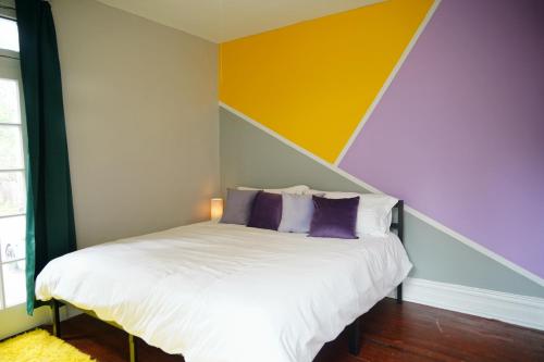 a bedroom with a bed with a colorful accent wall at Cute Neighborhood Rainbow Apt in Saint Louis