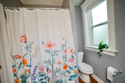 a bathroom with a shower curtain with flowers on it at Cute Neighborhood Rainbow Apt in Saint Louis