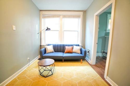 a living room with a blue couch and a window at Cute Neighborhood Rainbow Apt in Saint Louis