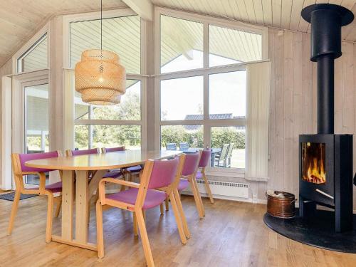 a dining room with a table and a fireplace at 4 star holiday home in Hals in Hals
