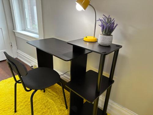 a black desk with a lamp and a chair at Cute Neighborhood Rainbow Apt in Saint Louis
