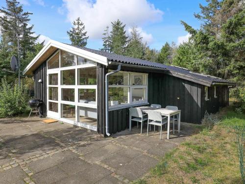 a small black shed with a table and chairs at 5 person holiday home in Jerup-By Traum in Jerup