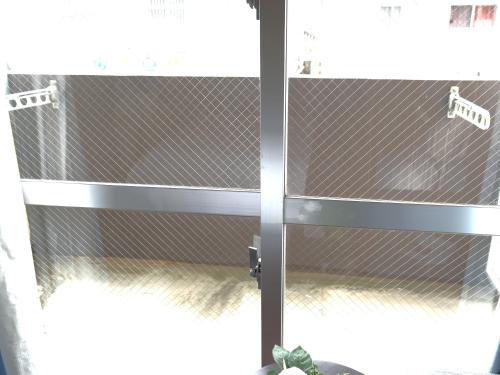 a glass door with a metal gate in a room at JC HOTEL NaHa in Naha