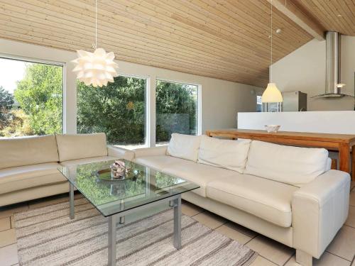 a living room with a couch and a glass table at 8 person holiday home in Ålbæk-By Traum in Ålbæk