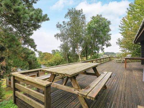 a wooden picnic table on a wooden deck at 6 person holiday home in Rudkøbing-By Traum in Spodsbjerg