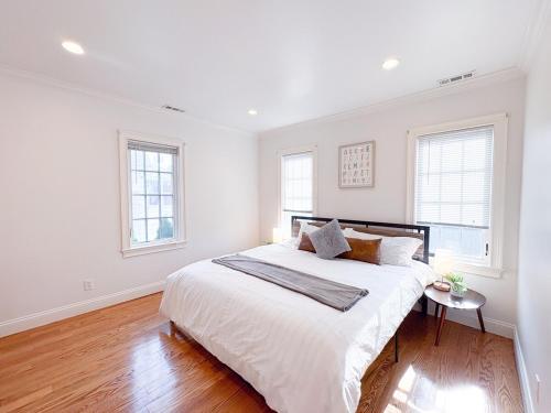 スタンフォードにあるFamily-Friendly 4 Bed 3 Bath Downtown Delightの白いベッドルーム(大型ベッド1台、窓2つ付)