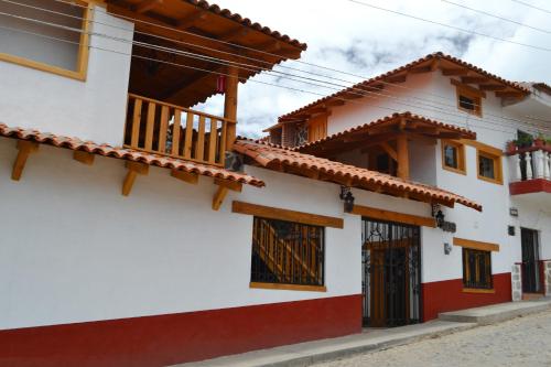 a white and red house with a balcony at Hoteles Viva Tapalpa in Tapalpa