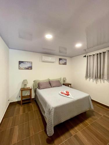 a bedroom with a bed and two tables and a window at Casa Menta in San Juan del Sur