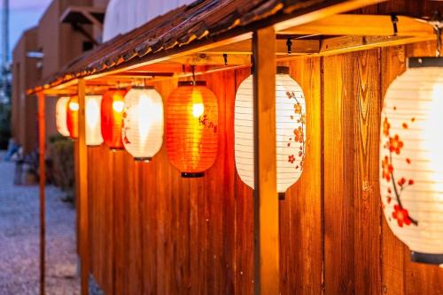a group of paper lanterns hanging from a wall at Gangneung Takenomori Glamping Ryokan in Gangneung