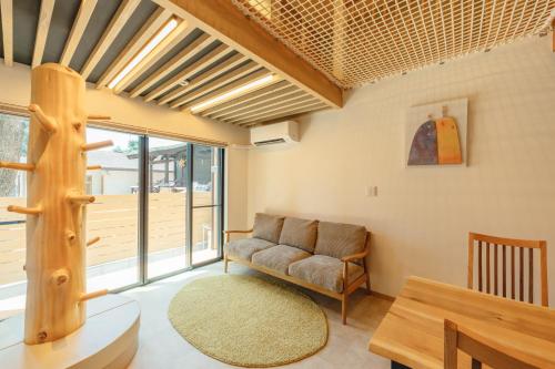 a living room with a chair and a table at YOUR ROOM treehouse KUMAMOTO in Kumamoto