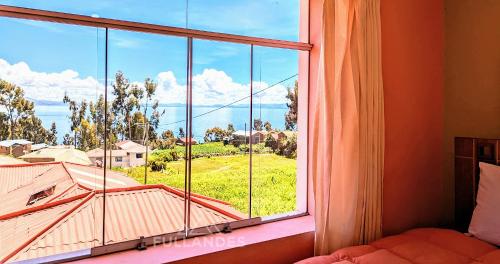a large window with a view of a house at Amantani sol Andino in Amantani