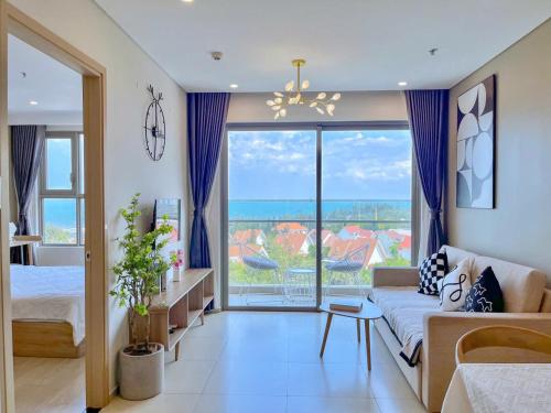 a living room with a couch and a large window at The Song Apartment - Căn Hộ The Sóng - Mai Villa Vũng Tàu in Vung Tau