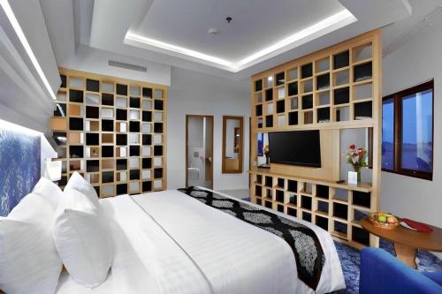a bedroom with a large white bed and a television at CK Tanjungpinang Hotel and Convention Centre in Tanjung Pinang 