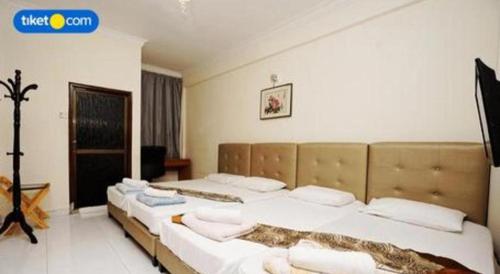 a bedroom with two beds with white pillows at Lai Ming Hotel Cosmoland in Singapore