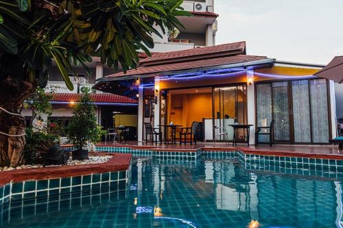 a house with a swimming pool in front of a house at Gazebo Resort Pattaya in Pattaya Central