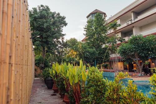 a garden with potted plants in front of a building at Gazebo Resort Pattaya in Pattaya Central