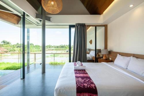 une chambre avec un grand lit et une grande fenêtre dans l'établissement Luxurious 2BR Villa with Private Pool & Rice Field Views in Ubud, à Ubud