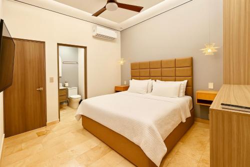 a bedroom with a large bed and a bathroom at Jungle Guardian - Rooftop Pool & Beach Club in Zona Hotelera Tulum in Tulum