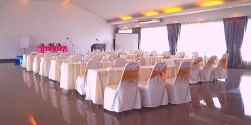 a banquet hall with white tables and chairs at Gazebo Resort Pattaya in Pattaya Central