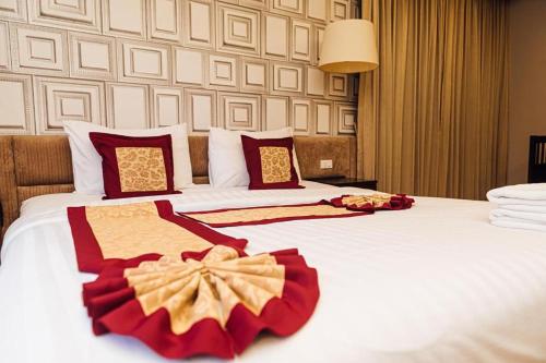 a hotel room with two beds with red and white sheets at Gazebo Resort Pattaya in Pattaya Central