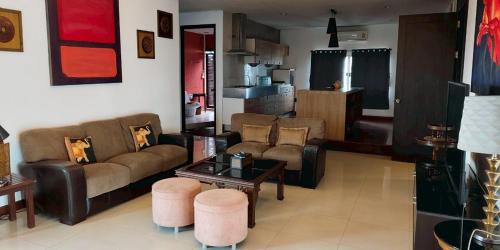 a living room with two couches and a table at Gazebo Resort Pattaya in Pattaya Central