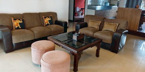 a living room with couches and a table and stools at Gazebo Resort Pattaya in Pattaya Central