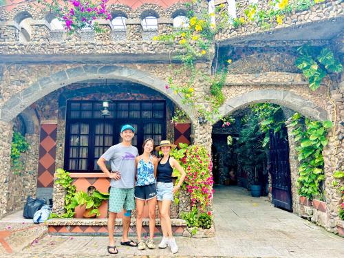 a group of three people standing in front of a building at Sầm Sơn Boutique Hotel Phan Thiết in Phan Thiet