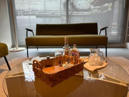 a basket of bottles on a glass table with a couch at 스테이지안 in Daegu