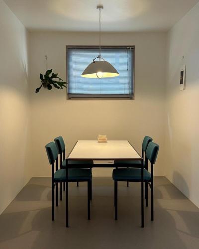 a dining room table with four chairs and a light at 스테이지안 in Daegu