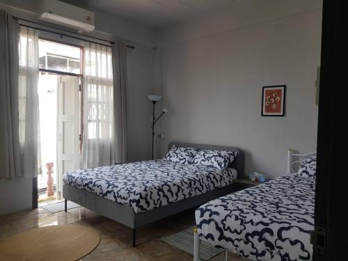 Dramatic Exit Bangkok - Cozy loft style near Suvarnabhumi Airport في بانكوك: غرفة نوم بها سريرين ونافذة