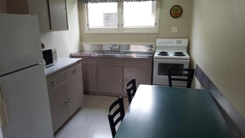a kitchen with a table and a stove and a sink at Manhattan Motel in Rotorua