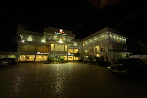 a large building with a parking lot at night at Sara Hotels and Apartments in Nedumbassery
