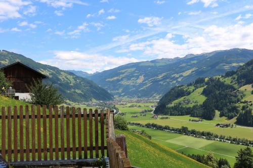 a bench on a hill with a view of a valley at DieAussicht - Refugium am Berg in Hippach