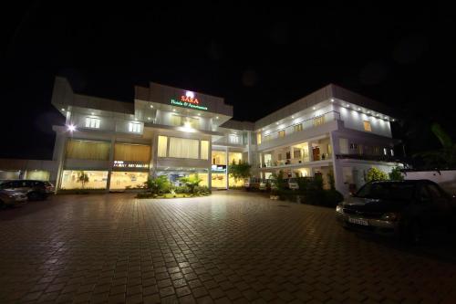 a building with a parking lot in front of it at night at Sara Hotels and Apartments in Nedumbassery