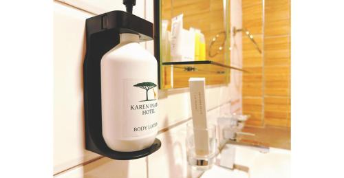 a bottle of soap on a bathroom sink at Karen Plains Hotel Nairobi in Nairobi
