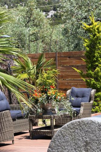 a patio with wicker chairs and a table with plants at Byblos Luxury Villa in Prinos