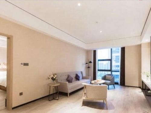 a living room with a couch and a bed at GRACE Select Hotel (Kunshan Huaqiao International Convention Center) in Suzhou
