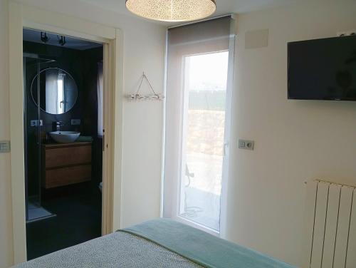 a bedroom with a bed and a sink and a mirror at La Casita de Suances 2 Ideal Familias y Mascotas in Suances