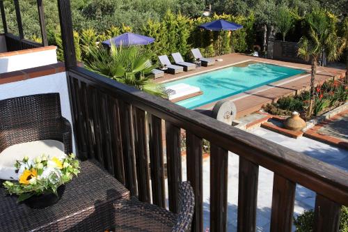 a balcony with a swimming pool with chairs and a table at Byblos Luxury Villa in Prinos
