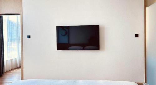 a flat screen tv on a white wall in a bedroom at Fairfield by Marriott Baoding High-Tech Zone in Baoding