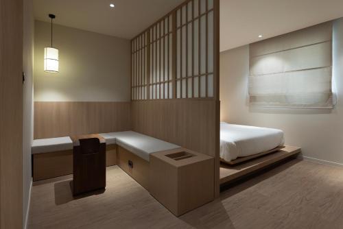 a bedroom with a bed and a bench and a window at Aank Ryokan Hotel Ansan Seonbu Branch in Ansan