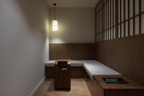 a room with a bench with a light on it at Aank Ryokan Hotel Ansan Seonbu Branch in Ansan