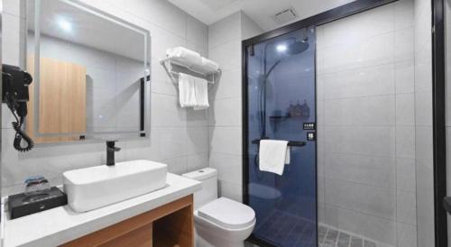 a bathroom with a shower and a sink and a toilet at GreenTree Inn Gaoyou Government in Yangzhou