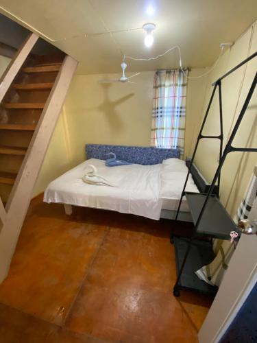 a small room with a bed and a staircase at Destiny Rainbow Beach Resort in Siquijor