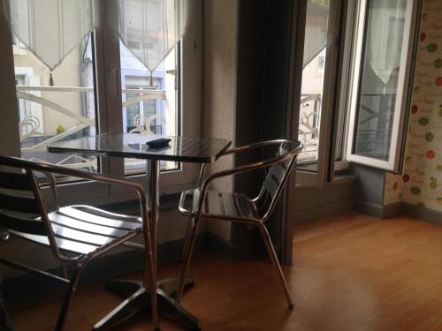 ブルボンヌ・レ・バンにあるStudios des Thermesの窓のある部屋(テーブルと椅子2脚付)