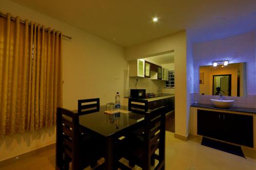 a kitchen and dining room with a table and chairs at Sara Hotels and Apartments in Nedumbassery